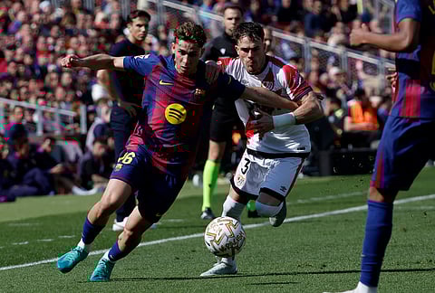 Barcelona's Fermin Lopez, left, and Rayo's Pep Chavarria run for the ball during a La Liga soccer match between Barcelona and Rayo Vallecano in Barcelona, Spain.