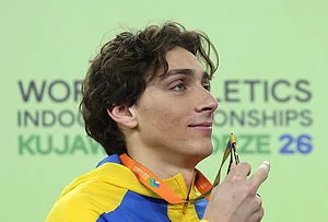 | Photo: AP/Beata Zawrzel : Armand Duplantis, of Sweden, poses on the podium after winning the gold medal in the men's pole vault at the World Athletics Indoor Championships in Torun, Poland.