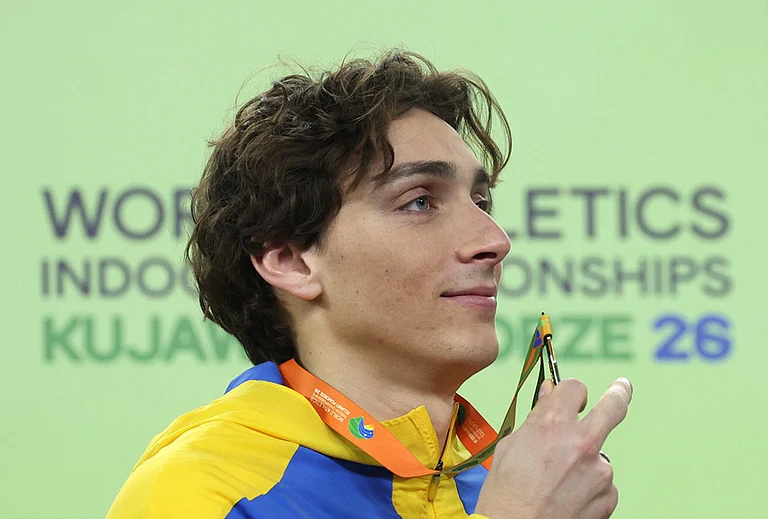 Armand Duplantis, of Sweden, poses on the podium after winning the gold medal in the men's pole vault at the World Athletics Indoor Championships in Torun, Poland. - | Photo: AP/Beata Zawrzel