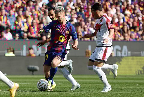 Barcelona's Dani Olmo in action by Rayo's Alfonso Espino during a La Liga soccer match between Barcelona and Rayo Vallecano in Barcelona, Spain.