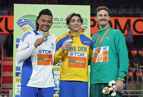 Silver medalist Emmanouil Karalis, of Greece, from left, gold medalist Armand Duplantis, of Sweden, and bronze medalist Kurtis Marschall, of Australia, pose on the podium of the men's pole vault at the World Athletics Indoor Championships in Torun, Poland.