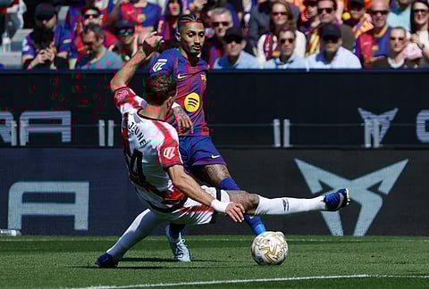 Rayo's Pedro Diaz, blocks Barcelona's Raphinha fight foduring a La Liga soccer match between Barcelona and Rayo Vallecano in Barcelona, Spain.