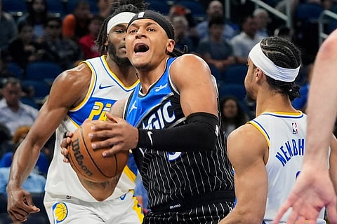Orlando Magic forward Paolo Banchero, center, tries to move past Indiana Pacers forward Jarace Walker, back left, and guard Andrew Nembhard, right, during the first half of an NBA basketball game in Orlando, Fla.