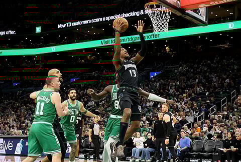 Minnesota Timberwolves guard Ayo Dosunmu (13) scores during the second half of an NBA basketball game against the Boston Celtics, in Boston. 