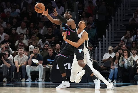 Miami Heat center Bam Adebayo (13) is fouled by San Antonio Spurs forward Victor Wembanyama, right, during the first half of an NBA basketball game, in Miami. 