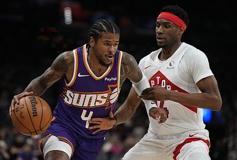 Phoenix Suns guard Jalen Green (4) drives past Toronto Raptors guard Ja'kobe Walter during the first half of an NBA basketball game, in Phoenix.