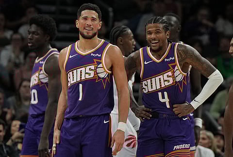 Phoenix Suns guard Devin Booker (1) and guard Jalen Green (4) celebrate after scoring against the Toronto Raptors during the second half of an NBA basketball game, in Phoenix.