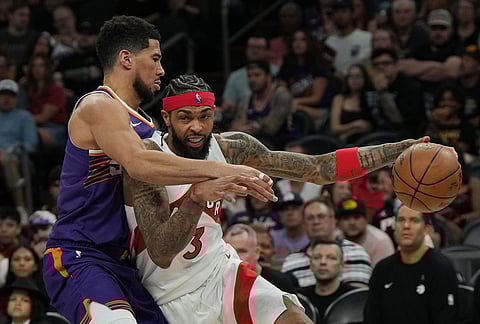 Toronto Raptors forward Brandon Ingram (3) shields the ball from Phoenix Suns guard Devin Booker during the second half of an NBA basketball game, in Phoenix.