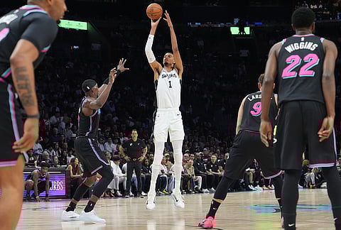 San Antonio Spurs forward Victor Wembanyama (1) shoots a three-point basket over Miami Heat center Bam Adebayo (13) during the first half of an NBA basketball game, in Miami.  