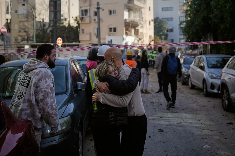 People react at the site of an Iranian missile strike in Tel Aviv, Israel, Tuesday, March 24, 2026. - AP Photo/Ohad Zwigenberg