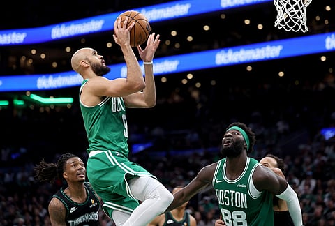 Boston Celtics guard Derrick White (9) scores during the second half of an NBA basketball game against the Minnesota Timberwolves, in Boston.