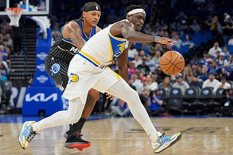 Indiana Pacers forward Pascal Siakam, right, goes after a loose ballin front of Orlando Magic forward Paolo Banchero during the first half of an NBA basketball game in Orlando, Fla.