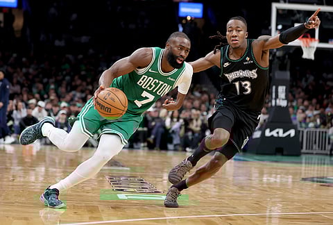 Boston Celtics forward Jaylen Brown (7) dribbles past Minnesota Timberwolves guard Ayo Dosunmu (13) during the second half of an NBA basketball game, in Boston. 