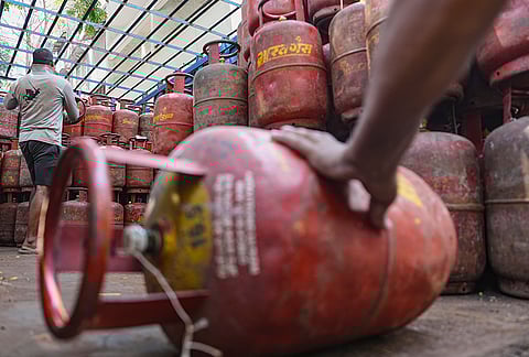 A worker loads cooking gas cylinders onto a delivery truck amid LPG supply disruptions, in Mumbai.