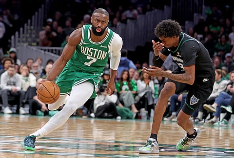 Boston Celtics forward Jaylen Brown (7) maneuvers the ball around Minnesota Timberwolves forward Jaden McDaniels (3) during the second half of an NBA basketball game, in Boston.