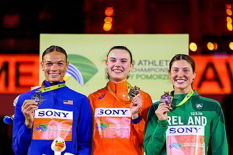 From left to right, Anna Hall, of the United States, Sofie Dokter, of the Netherlands, and Kate O'Connor, of Ireland, pose for photos after winning medals in the women's pentathlon at the World Athletics Indoor Championships in Torun, Poland.