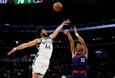 LA Clippers guard Cam Christie (12) takes a shot while being guarded by Milwaukee Bucks guard Andre Jackson Jr. (44) during the second half of an NBA basketball game Inglewood, California.