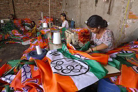 A worker makes flags depicting the TMC party logo ahead of the election in various constituencies, in Mathura.