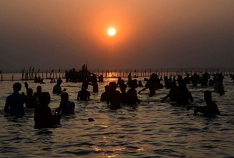 Devotees take a dip in the Ganga river during sunrise for the ‘Chaiti Chhath’ festival, in Patna.