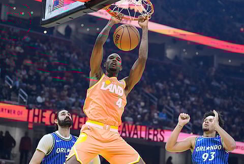 Cleveland Cavaliers center Evan Mobley (4) dunks between Orlando Magic center Goga Bitadze, left, and forward Noah Penda (93) in the first half of an NBA basketball game in Cleveland.