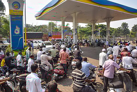 Commuters on their two-wheelers wait in a queue outside a gas station following the rumours of fuel shortage in the wake of the West Asian conflict, in Karad.