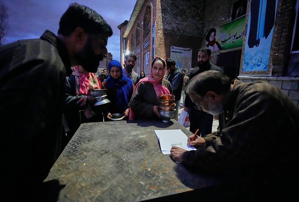 Shiite Muslim women wait to donate copper kitchenware during a relief drive for Iran in Budgam, Kashmir.