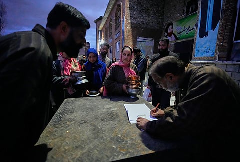 Shiite Muslim women wait to donate copper kitchenware during a relief drive for Iran in Budgam, Kashmir.