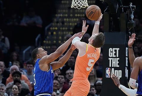 Cleveland Cavaliers guard Sam Merrill (5) is fouled by Orlando Magic guard Desmond Bane, left, in the second half of an NBA basketball game in Cleveland.