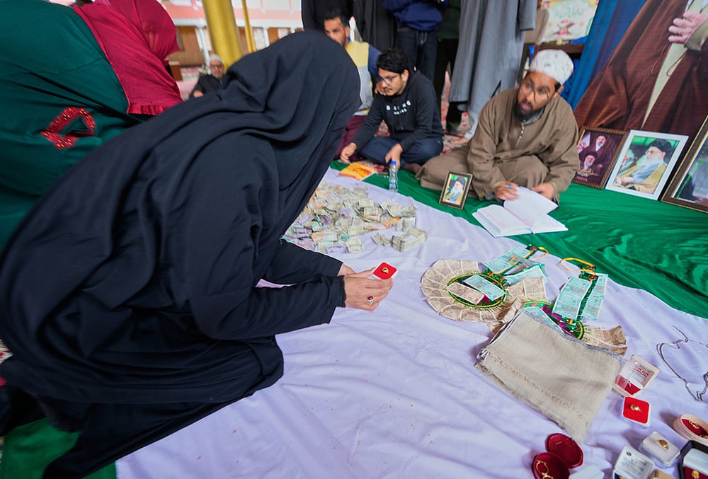 A Shiite Muslim woman donates her ring during a relief drive for Iran in Budgam, Kashmir.