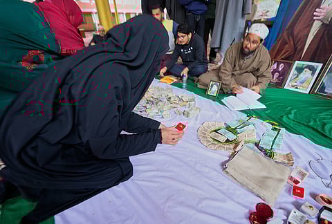 A Shiite Muslim woman donates her ring during a relief drive for Iran in Budgam, Kashmir.