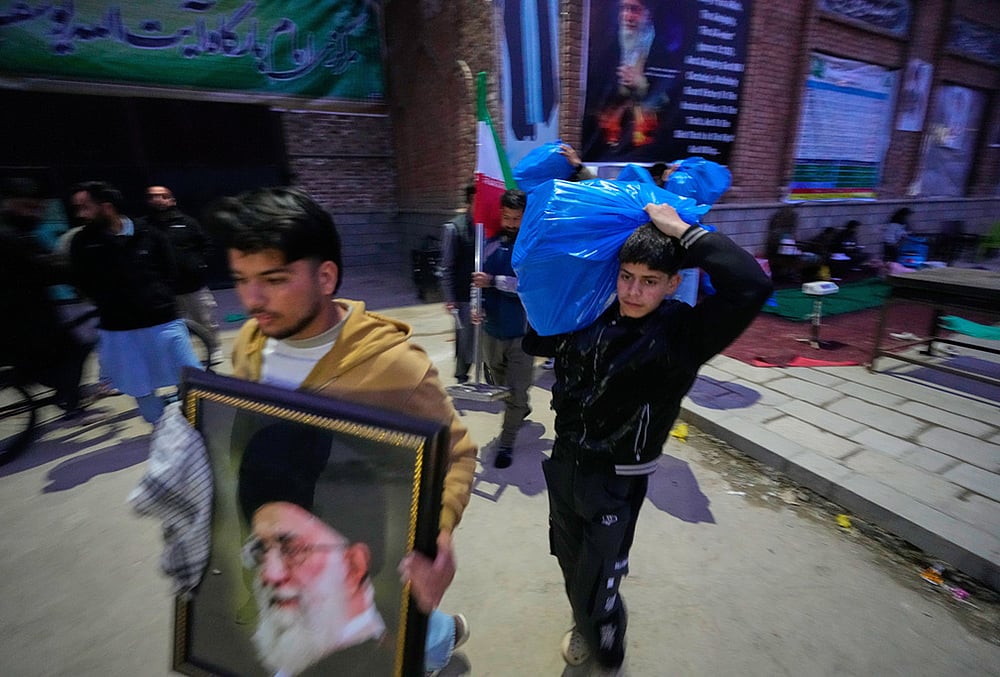 A boy carries a plastic bag of donated items collected during a relief drive for Iran in Budgam, Kashmir.