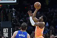 | Photo: AP/Sue Ogrocki : Cleveland Cavaliers guard Donovan Mitchell, right, shoots in front of Orlando Magic forward Moritz Wagner, left, in the second half of an NBA basketball game in Cleveland.