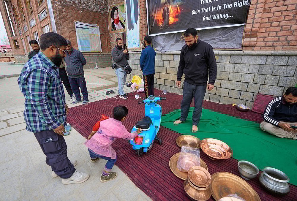 A boy donates his toy scooter during a relief drive for Iran in Budgam, Kashmir.