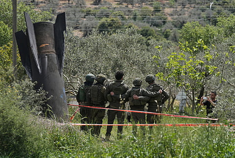 Israeli soldiers take their photo beside the wreckage of an Iranian missile that landed in the West Bank village of Kifl Haris. 