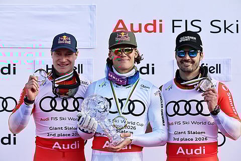 Brazil's Lucas Pinheiro Braathen, center, holds the globe trophy for the alpine ski, men's giant slalom discipline title, next to second-ranked Switzerland's Marco Odermatt, left, and third-ranked Switzerland's Loic Meillard, at the Lillehammer World Cup Finals, in Hafjell, Norway.