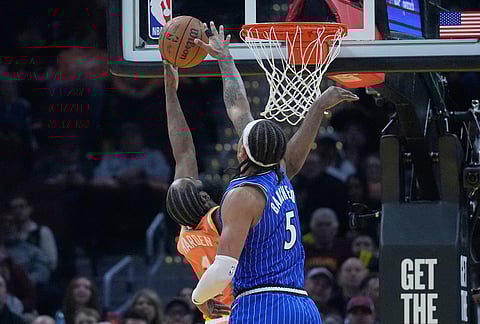 Cleveland Cavaliers guard James Harden, left, shoots as Orlando Magic forward Paolo Banchero (5) defends in the second half of an NBA basketball game in Cleveland.