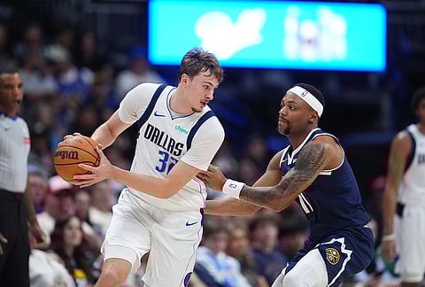 Dallas Mavericks forward Cooper Flagg, left, looks to pass the ball as Denver Nuggets guard Bruce Brown defends in the second half of an NBA basketball game in Denver.