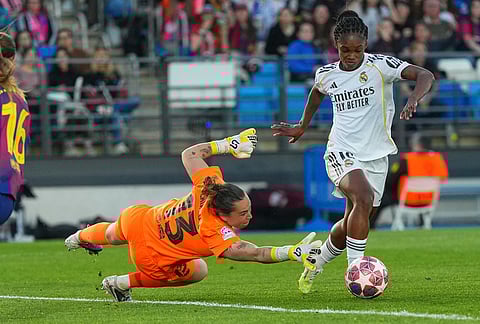 Real Madrid's Linda Caicedo, right, rounds Barcelona's goalkeeper Cata Coll to score her side's first goal during the women's Champions League quarterfinal first leg soccer match between Real Madrid and Barcelona in Madrid, Spain.