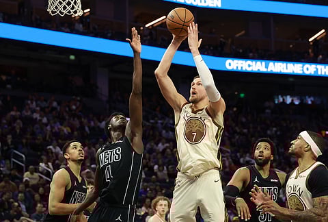 Golden State Warriors center Kristaps Porzingis (7) shoots against Brooklyn Nets guard Drake Powell (4) during the second half of an NBA basketball game in San Francisco.