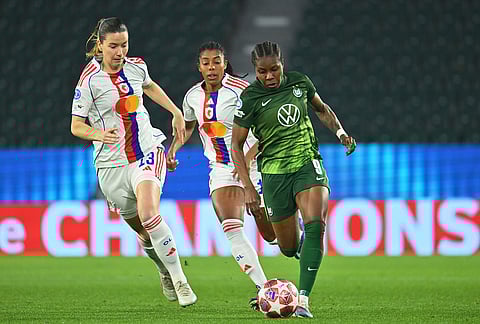 Wolfburg's Lineth Beerensteyn, right, dribbles past Lyon's Damaris Egurrola during their Champions League quarter-finals, first leg soccer match in Wolfsburg, Germany.