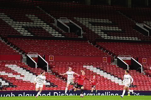A general view of the empty seats as Bayern Munich's Franziska Kett, center left, and Manchester United's Lea Schuller battle for the ball during the Women's Champions League match between Manchester United and Bayern Munich in Manchester, England.