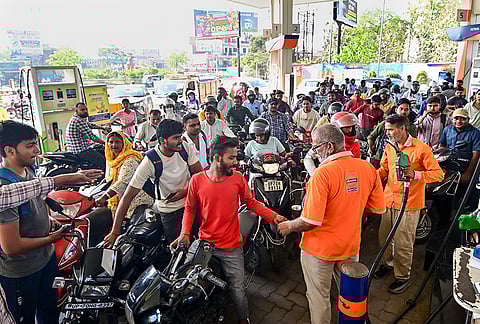 People queue up at a petrol pump amid rumours of fuel shortage in the wake of the West Asian conflict, in Prayagraj, Uttar Pradesh.