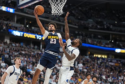 Denver Nuggets forward Cameron Johnson, left, drives to the rim past Dallas Mavericks forward Naji Marshall in the second half of an NBA basketball game in Denver. 