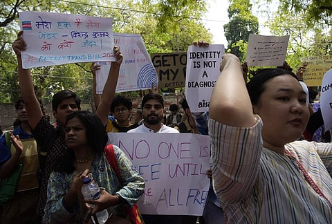 Supporters of the LGBTQIA+ community hold placards during a protest against the passage of the Transgender Persons (Protection of Rights) Amendment Bill, 2026, at Jantar Mantar in New Delhi.