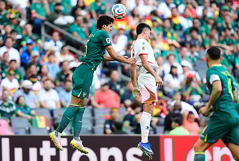 Bolivia's Efrain Morales, left, heads the ball past Suriname's Joel Piroe during a World Cup playoff semifinal soccer match between Bolivia and Suriname in Monterrey, Mexico.