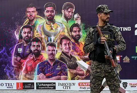 A paramilitary soldier stands guard to ensure security at outside the Gaddafi Stadium, where opening cricket match of the Pakistan Super League between Lahore Qalandars and Hyderabad Kingsmen is taking place without spectators, in Lahore, Pakistan.