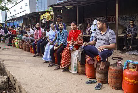 People wait in a queue with empty cylinders to avail refilled ones amid ongoing supply crisis, at Noida, in Gautam Buddha Nagar district, Uttar Pradesh.