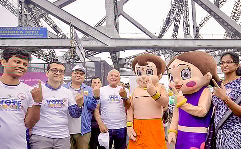 People show their index finger during a cycle rally on Howrah Bridge as a part of an awareness campaign for voters by the Election Commission ahead of the West Bengal Assembly Election, in Howrah district.