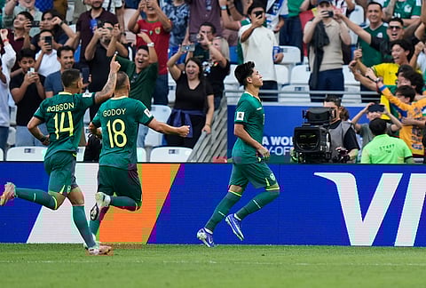 Bolivia's Miguel Terceros, right, celebrates scoring his side's 2nd goal from the penalty spot during a World Cup playoff semifinal soccer match between Bolivia and Suriname in Monterrey, Mexico.