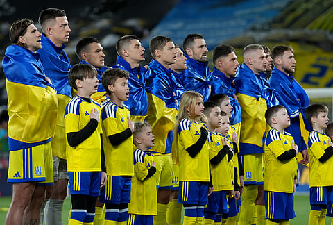 Ukrainian players sing the national anthem ahead of the World Cup playoff semifinal soccer match between Ukraine and Sweden in Valencia, Spain.